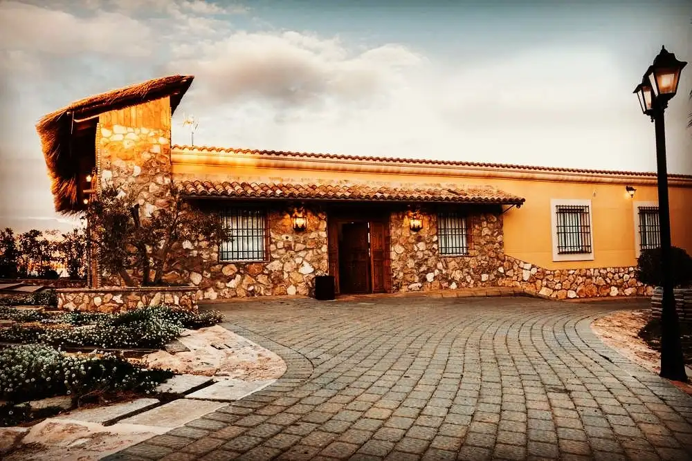 La casa de piedra y teja al atardecer, con su farola y el suelo empedrado