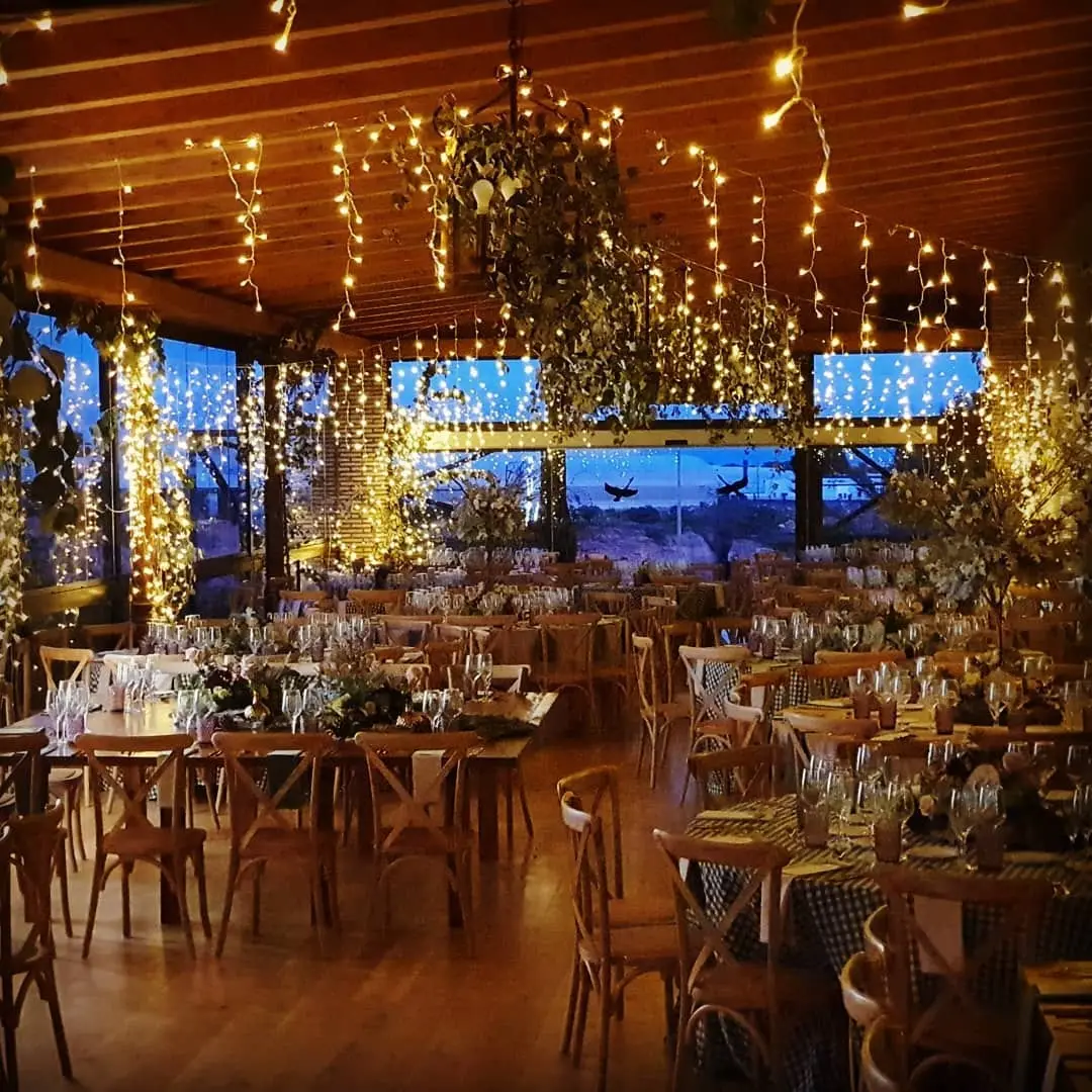 El salón preparado para un banquete, con cortinas de luces y vistas por los ventanales